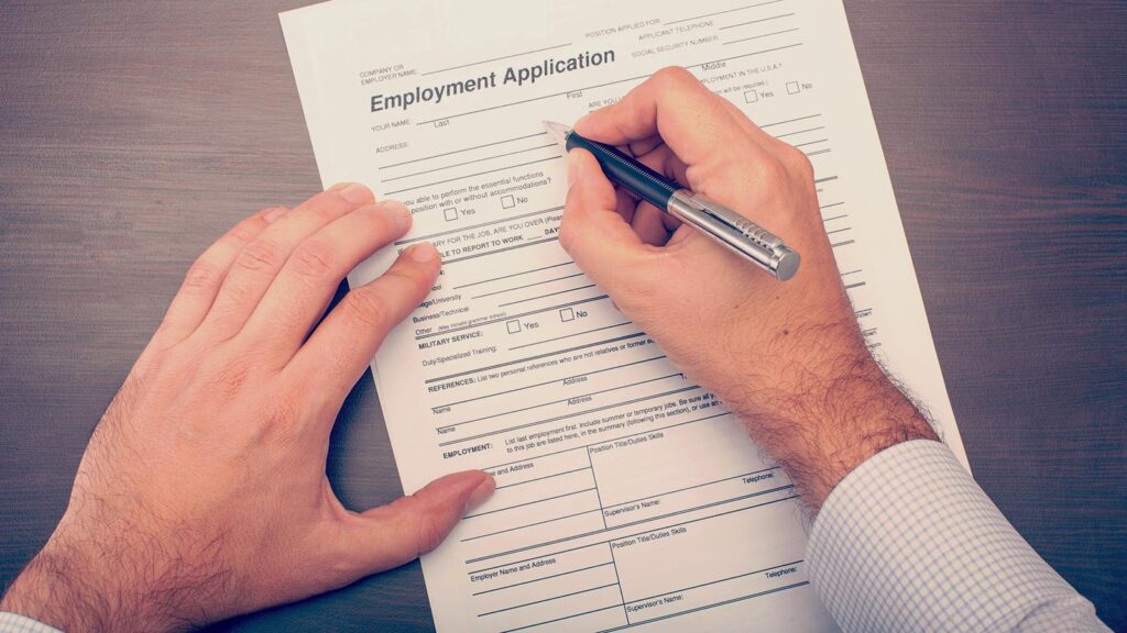 Person filling out employment application form